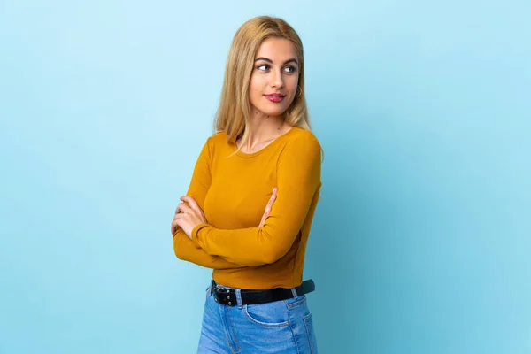 Jovem Loira Uruguaia Sobre Fundo Azul Isolado Mantendo Braços Cruzados — Fotografia de Stock