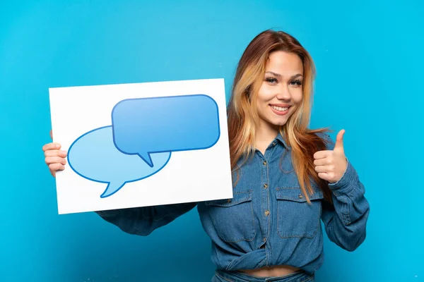 Chica Adolescente Sobre Fondo Azul Aislado Sosteniendo Cartel Con Icono —  Fotos de Stock