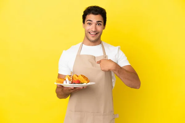 Restaurant Ober Houden Wafels Geïsoleerde Gele Achtergrond Met Verrassing Gezichtsuitdrukking — Stockfoto