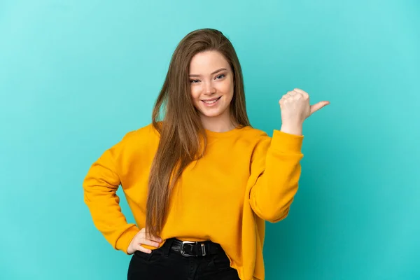 Adolescente Chica Sobre Aislado Fondo Azul Apuntando Lado Para Presentar —  Fotos de Stock