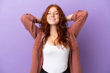 Genç kızıl saçlı kız, izole edilmiş mor arka planda gülüyor.