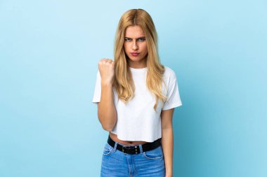 Genç Uruguaylı sarışın kadın mutsuz bir ifadeyle izole edilmiş mavi arka plan