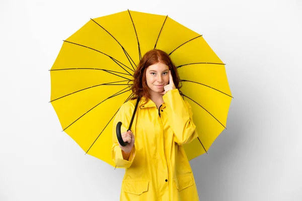 ティーンRedhead女の子雨防止コートと傘隔離上の白い背景考え方 — ストック写真
