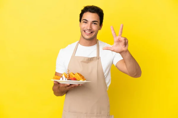 Restaurantkellner Hält Waffeln Glücklich Vor Gelbem Hintergrund Und Zählt Mit — Stockfoto