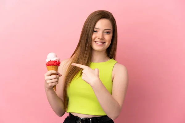 Tiener Meisje Met Een Cornet Ijs Geïsoleerde Roze Achtergrond Wijzend — Stockfoto