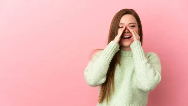 ティーン少女上の隔離されたピンクの背景叫びと何かを発表 — ストック写真