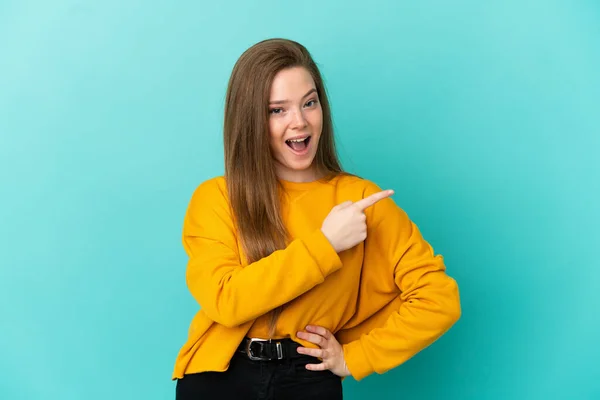 Adolescente Menina Sobre Isolado Fundo Azul Surpreso Apontando Lado — Fotografia de Stock