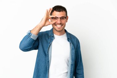 İzole edilmiş beyaz arka plan üzerinde Brezilyalı bir adam parmaklarıyla tamam işareti gösteriyor