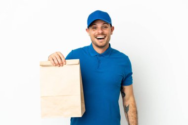 Brezilyalı, beyaz arka planda izole edilmiş, sürpriz bir yüz ifadesiyle paket yiyecek alıyor.