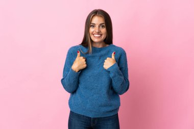 Genç Uruguaylı kadın pembe arka planda yalıtılmış ve yüzünde sürpriz bir ifade var.