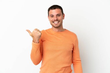 İzole edilmiş beyaz arka plan üzerinde Brezilyalı bir adam bir ürün sunmak için kenarı işaret ediyor