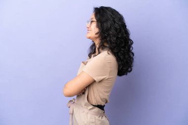 Restoran Asyalı garson, mor arka planda yan pozisyonda izole edilmiş.