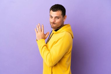 İzole edilmiş mor arka plan entrikaları yapan Brezilyalı bir adam.