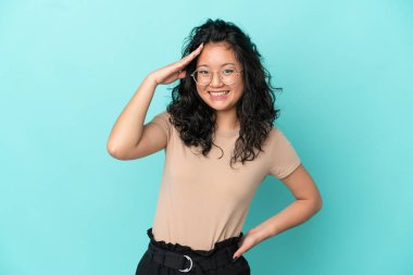 Mavi arka planda izole edilmiş genç Asyalı kadın bir şey fark etti ve çözüme niyetlendi.