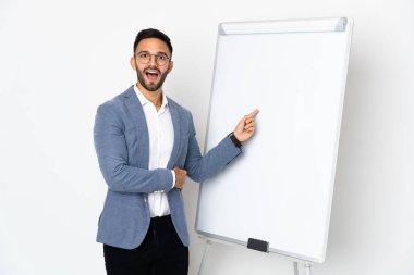 Beyaz arka planda izole edilmiş genç beyaz bir adam beyaz tahtada sunum yapıyor.