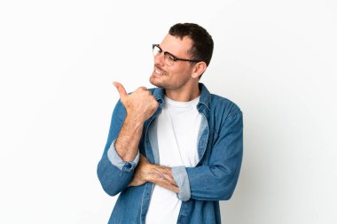 İzole edilmiş beyaz arka plan üzerinde Brezilyalı bir adam bir ürün sunmak için kenarı işaret ediyor