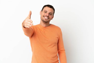 İzole edilmiş beyaz arka plan üzerinde Brezilyalı bir adam iyi bir anlaşma için el sıkışıyor