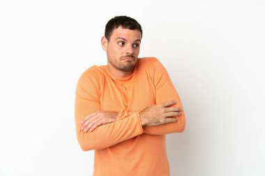 Brezilya 'lı beyaz arka planda kalan adam, omuzlarını kaldırırken şüphe jesti yapıyor.