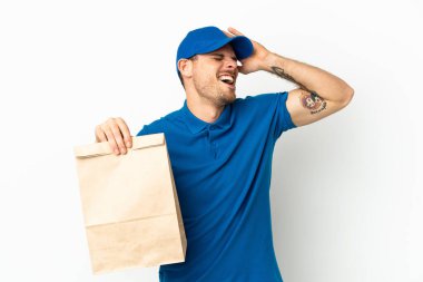 Brezilyalı, beyaz arka planda izole edilmiş bir paket yiyecek alıyor. Çok gülümsüyor.