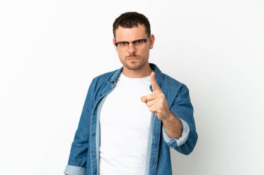 İzole edilmiş beyaz arka plan üzerinde Brezilyalı bir adam hayal kırıklığına uğramış ve ön tarafı işaret ediyor.