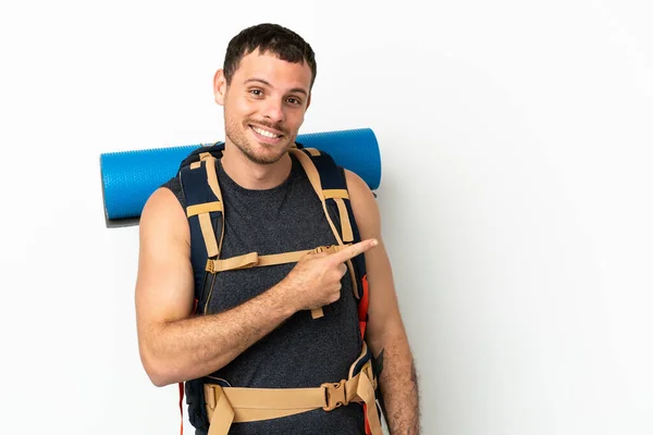 ブラジルの登山家男とともに大きなバックパック上の隔離された白い背景指差し指へ側 — ストック写真
