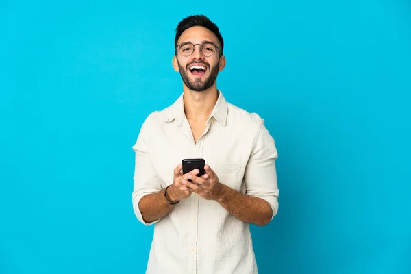 Joven Caucásico Aislado Sobre Fondo Azul Sorprendido Enviando Mensaje —  Fotos de Stock