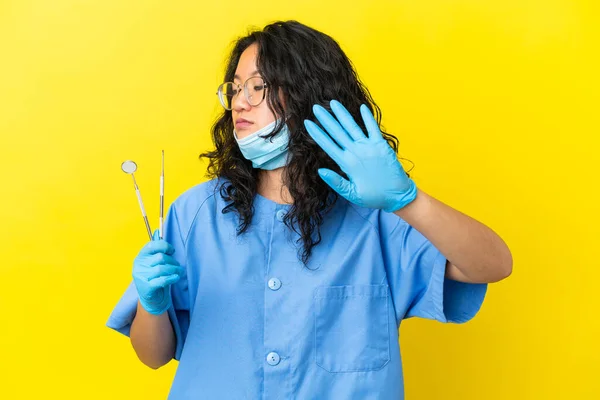 年轻的亚洲牙医拿着工具在孤立的背景下做停止手势和失望 — 图库照片