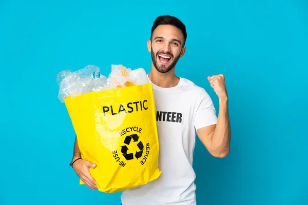 Młody Biały Mężczyzna Trzymając Worek Pełen Plastikowych Butelek Recyklingu Odizolowany — Zdjęcie stockowe