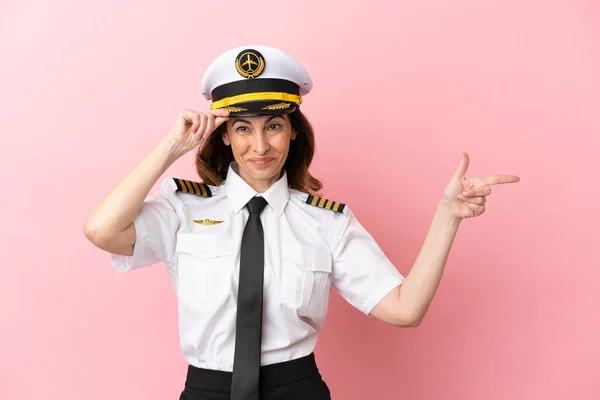 Αεροπλάνο Μεσήλικας Πιλότος Γυναίκα Απομονωμένη Ροζ Φόντο Έκπληκτος Και Δείχνοντας — Φωτογραφία Αρχείου