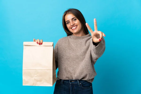 Frau Mit Einer Tüte Essen Zum Mitnehmen Auf Blauem Hintergrund — Stockfoto