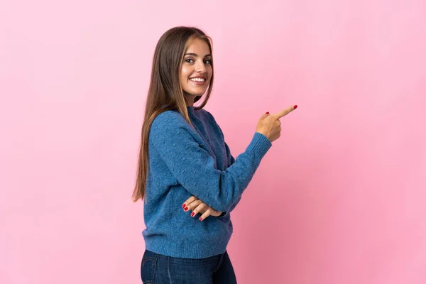 Jovem Uruguaia Isolada Sobre Fundo Rosa Apontando Dedo Para Lado — Fotografia de Stock