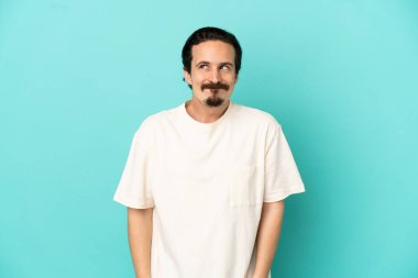 Kafkasyalı genç adam mavi arka planda izole edildi.