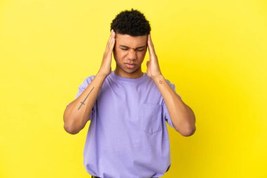 Genç Afrikalı Amerikalı adam sarı arka planda baş ağrısı ile izole edildi