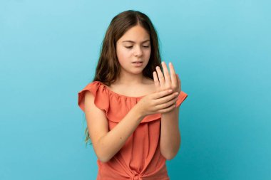 Küçük beyaz kız mavi arka planda izole edilmiş ellerindeki acıdan muzdarip.