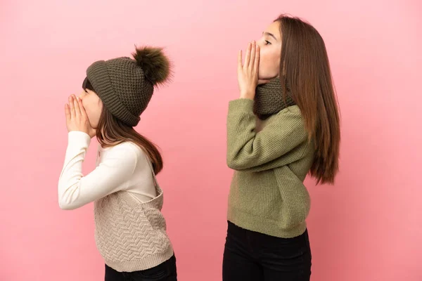 Hermanitas Vestidas Con Ropa Invierno Aisladas Sobre Fondo Rosa Gritando —  Fotos de Stock