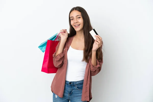 ショッピングバッグとクレジットカードを持っている白い背景に隔離された若いフランス人の女の子 — ストック写真