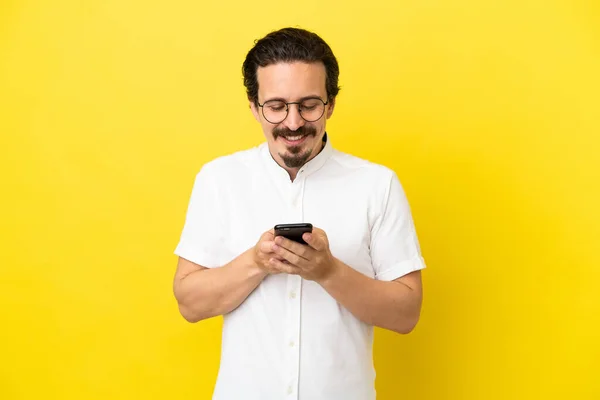Sarı Arka Planda Izole Edilmiş Genç Beyaz Adam Cep Telefonuyla — Stok fotoğraf