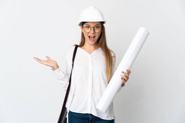 Young Lithuanian architect woman with helmet and holding blueprints isolated on white background with shocked facial expression