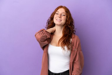 Genç kızıl saçlı kız, izole edilmiş mor arka planda gülüyor.