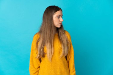 Genç Litvanyalı kadın mavi arka planda izole edilmiş.