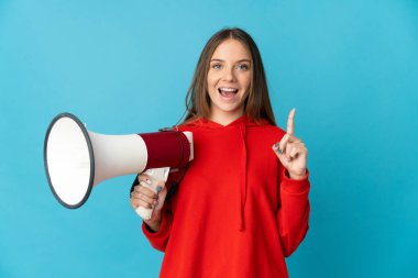 Young Lithuanian woman isolated on blue background holding a megaphone and pointing up a great idea