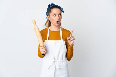 Young Lithuanian woman holding a rolling pin isolated on white background thinking an idea pointing the finger up
