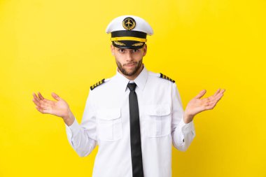 Kafkasyalı pilot sarı arka planda izole edildi. El kaldırırken şüpheleri vardı.