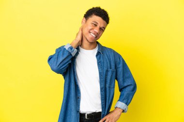 Genç Afrikalı Amerikalı adam sarı arka planda izole edilmiş gülüyor.