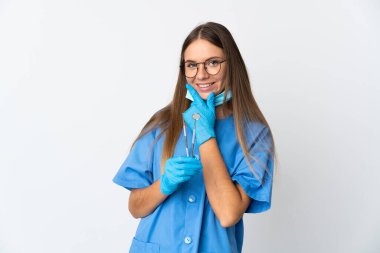Lithuanian woman dentist holding tools over isolated background happy and smiling