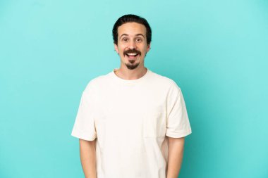 Mavi arka planda yalıtılmış beyaz bir adam. Şaşırtıcı bir yüz ifadesi var.