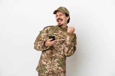 Asker beyaz arka planda izole edilmiş ve telefon zafer pozisyonunda.