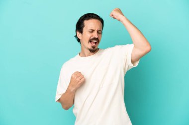 Mavi arka planda izole edilmiş beyaz bir adam zaferi kutluyor.