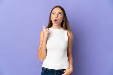 Young Lithuanian woman isolated on purple background thinking an idea pointing the finger up