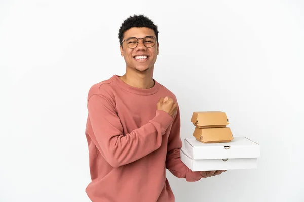 Junger Afroamerikaner Mit Burger Und Pizzen Auf Weißem Hintergrund Feiert — Stockfoto